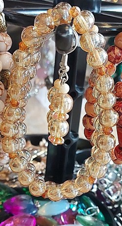 Oranje tinten beads met strass tussenstukjes. €10-,