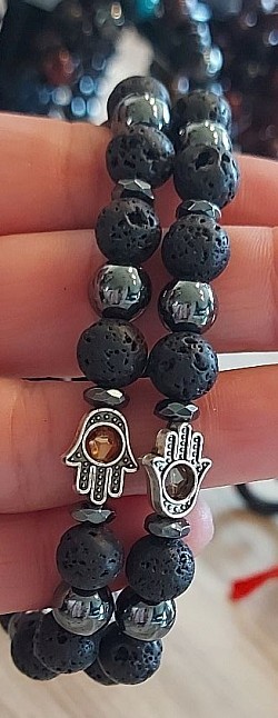 Lavasteen en hematiet met een zilveren buddha handje: Hematiet is een sterk aardende, zuiverende en beschermende steen. €10-,