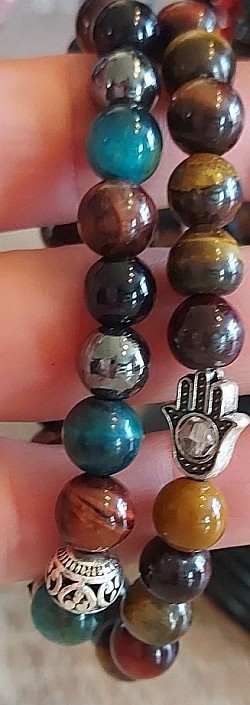Multicolour tijgeroog met zilveren beads en Fatima handje: Tijgeroog is een beschermende steen die de aandacht naar binnen richt en naar het grotere geheel. €10-,