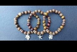 Houten beads met tijgeroog en zilveren tussen stukjes met een zilveren bedeltje. €10-,