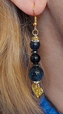 Gouden oorhangers in Zandsteen met obsidiaan: Obsidiaan is een sterk inzichtgevende en reinigende steen en stimuleert persoonlijke ontwikkeling door (zelf)inzicht en het opruimen van bagage uit het verleden. €12,50-,